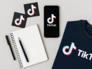 How Often Should You Post on TikTok in 2025? Flat lay of TikTok-branded sweatshirt, smartphone, notebook, and pen symbolizing content planning for creators