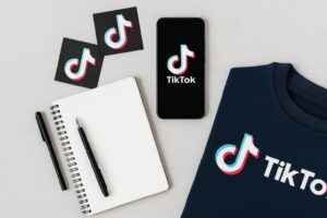 Flat lay of TikTok-branded sweatshirt, smartphone, notebook, and pen symbolizing content planning for creators